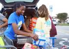 CCLP/LYNETTE SOWELL - DECA Club member Ariana Wilson helps load donated food items after a food drive held at Walmart on Friday. The club collected food for the CCHS weekend food backpack program to help fellow CCHS students in need.