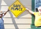 CCLP/DAVID J. HARDIN - Copperas Cove Soup Kitchen director Patrick Richardson and Kelly Jenkins of Central Texas Youth Services hold up the new Safe Place sign, which designates the soup kitchen as a place where at-risk youths can go if they are in trouble and need.