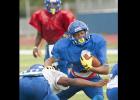 CCLP/DAVID MORRIS - Cove senior running back Elijah Washington attempts to elude a tackler as senior quarterback Caine Garner looks on during the Bulldawgs’ annual Soap, Towel and Shampoo scrimmage Saturday at Bulldawg Stadium.