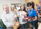 CCLP/DAVID MORRIS - Western Insurance president Tom Boren draws a winner from the basket of business cards during the monthly chamber mixer. hosted by the insurance agency.