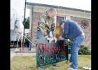 CCLP/LYNETTE SOWELL - Christian Mulvey, with the help of his son-in-law Dustin Phipps, installs a sign that’s part of a Christmas lights display synchronized to music. Mulvey will have his 3rd annual light display, this year he is accepting donations for Hope Pregnancy Center.