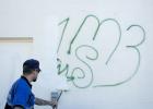 Senior code compliance officer, Beau Brabbin, paints over a gang tagging left on the rear of Mighty Mart Jan. 28. With the help of volunteers the tagging and profanity were covered at no cost to the store that opened at the end of 2013.