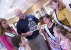 Crown sponsor Bill French unveils the Ambassador crown as the 2014 Rabbit Fest royalty look on.