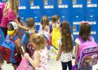 Devin Kasa helps her class find their lockers during the first morning session at Mae Stevens Early Learning Academy.