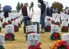 CCLP/FILE ART - Volunteers pause at a grave during last years wreath laying ceremony at the Central Texas State Veterans Cemetery. This year Marty Smith is looking for 300 volunteers to help lay 2,300 wreaths.