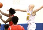 CCLP/TJ MAXWELL -- Cove senior Wyatt Behara attempts a block as Harker Heights senior Davon Clare scores on a reverse layup during the Knights’ 59-52 win over the Dawgs on Friday.