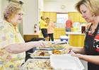 Margaret Martin, left, helps Lulu Maples prepare a boxed catfish and brisket meal at Pidcoke United Methodist Church’s Big Feed on Saturday.