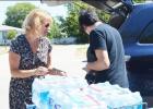 Silvia Rhoads, left, gets some help unloading 10 cases of water at Cove House on Monday afternoon, as part of her Ice Bucket Challenge.