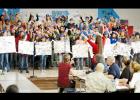 Students perform a patriot barrage of songs during a celebration honoring veterans, Monday morning. Ralf, a veteran service dog, led the parade of veterans through the halls of the campus.