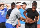 Copperas Cove assistant coach Ryan Youngblood hands off the  all to incoming freshman Miles Alexander as others look on during running back drills on Monday as part of the 2014 Copperas Cove NFL Football Camp at Bulldawg Stadium.