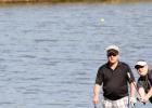 Joe Garland watches his pitch shot travel towards the pin on hole eight as his teammate Fred Cosper looks on during the Copperas Cove Lions Club 26th Annual Golf Tournament Saturday at the Hills of Cove Golf Course in Copperas Cove.