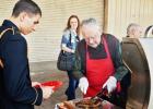 Woody Shemwell, one of seven grill volunteers, checks a steak at Thursday night’s military affairs banquet hosted by the chamber of commerce.