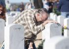 Bruce Ellyson kneels at the stone of his wife during the wreath placement Saturday in Killeen. Thousands of volunteers gathered for the 10th annual event, decorating more than 5,000 veteran’s headstones in the Central Texas State Veterans Cemetery.