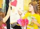 House Creek Elementary School 3rd grader Jenny Edmunds, 9, sells 2-D flower art to a student buyer through the open market project.