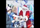 Santa draws a winning ticket for a $25 American Express gift card at the Small Business Saturday kickoff party in the Cove Terrace Shopping Center.