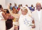 Christina waves to her family as she makes her way down the aisle with her husband, Leroy Lemmon.